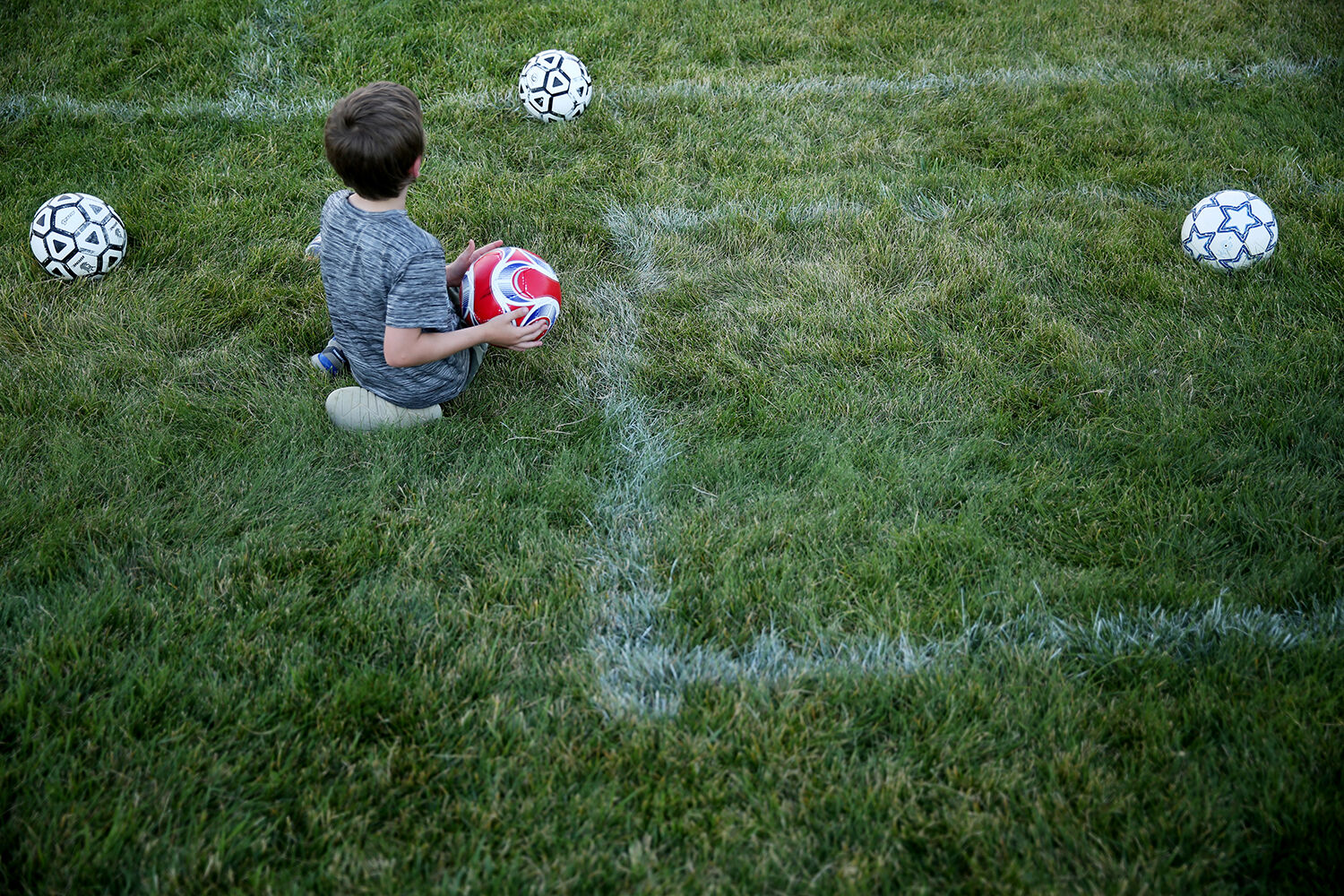 Noah Garland, 7, sits on the sideline of the field waiting to be subbed in